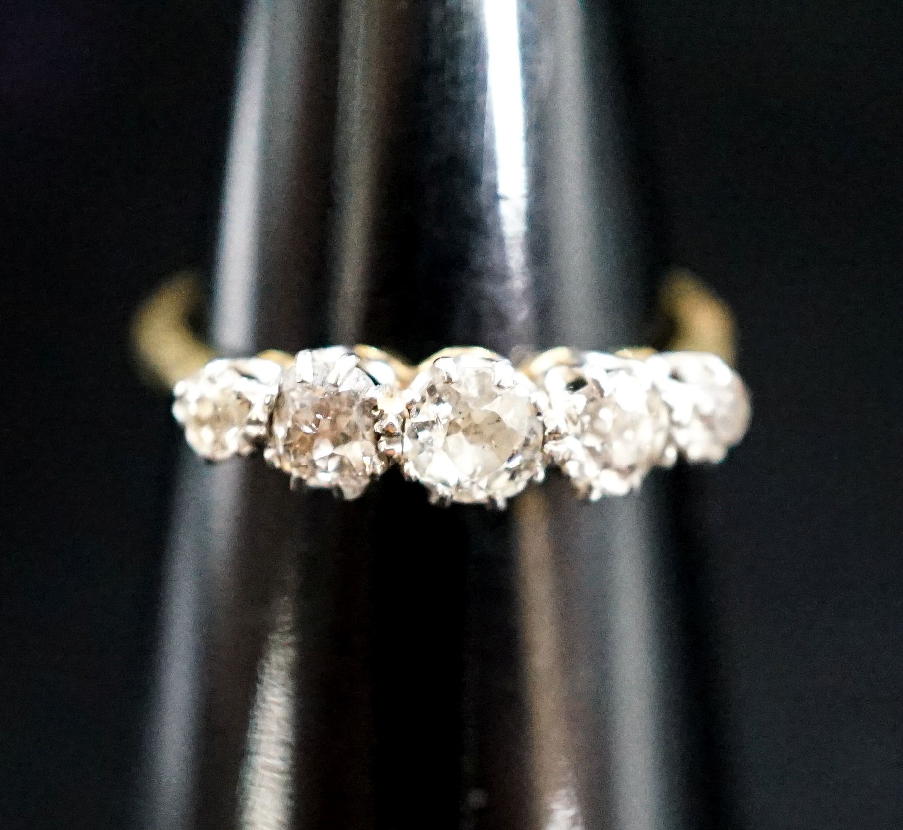 An 18ct, plat and graduated five stone diamond set half hoop ring, size N, gross 3.1 grams.